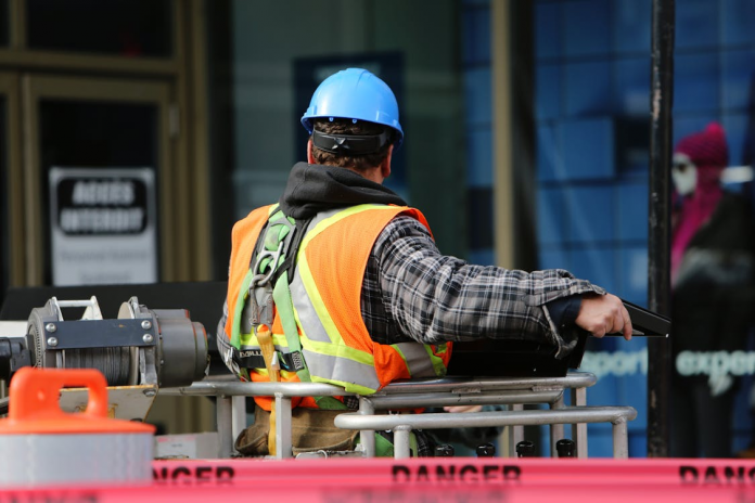 Man with hard hat and vest working in hazardous setting